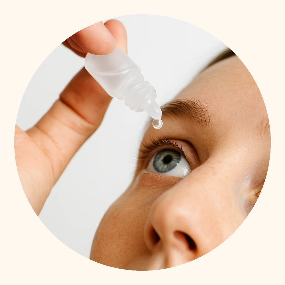 Persona aplicando gotas oculares sobre el ojo, fotografía realista en fondo claro.